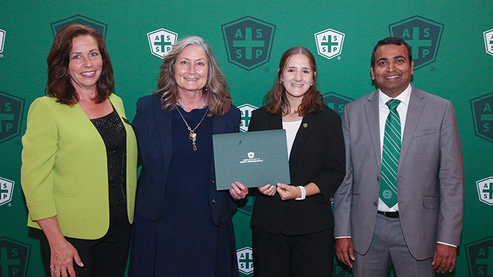 Four people standing side by side in front of an ASSP backdrop with one holding a certificate.