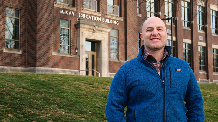 Man in jacket standing outside McKay Education Building