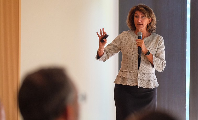 Karen Riley holding microphone and presenting.