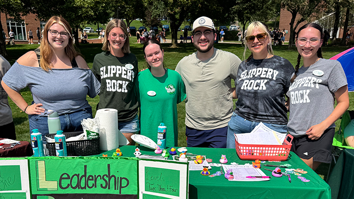 Six students posed and standing behind a table at the SRU Involvement Fair.