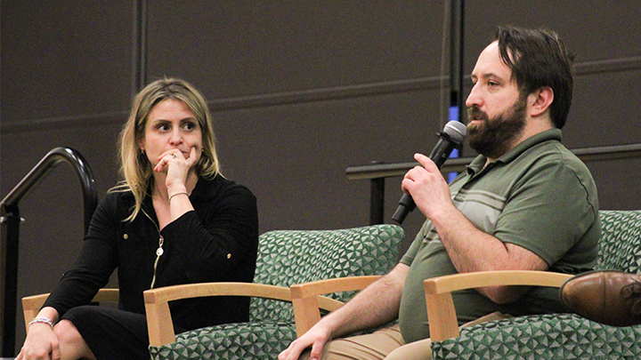 Brittany Fleming sits next to James Cressman who is holding a microphone.