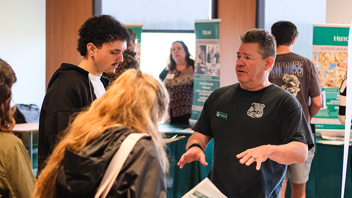 Professor talking to a prospective student and their parent.
