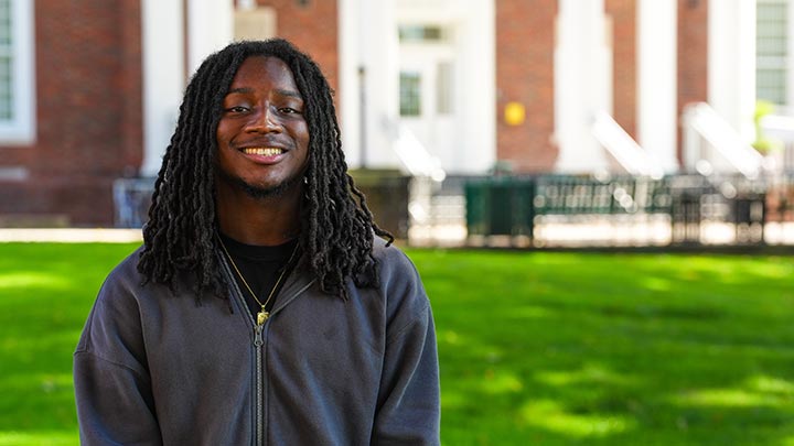 Portrait of man smiling in front of a building.